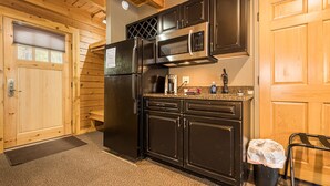 A kitchen with wooden cabinets, a refrigerator, a microwave, and a coffee maker.