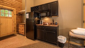 A compact kitchen with a refrigerator, microwave, and sink.