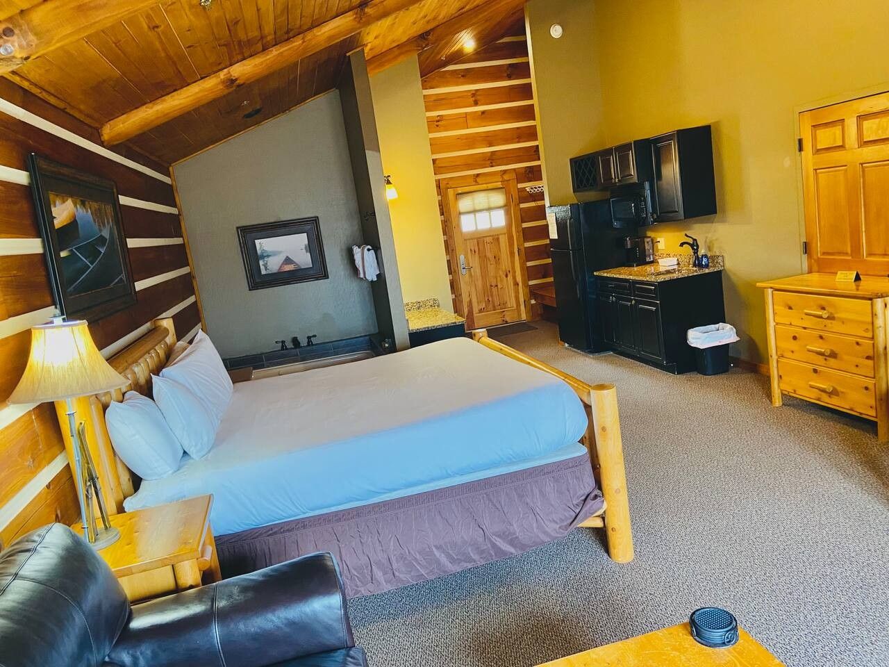 Una habitación con una cama, un escritorio, una silla, un televisor y un armario de madera.