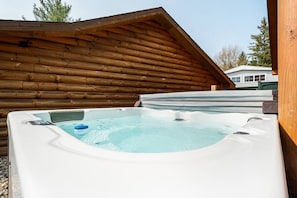 A hot tub in a wooden cabin with a clear view of the surrounding area.