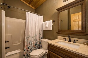 A bathroom with a bathtub, toilet, and sink.