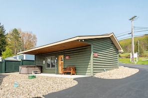 Eine Blockhütte mit Veranda, einer Bank und einem Mülleimer.