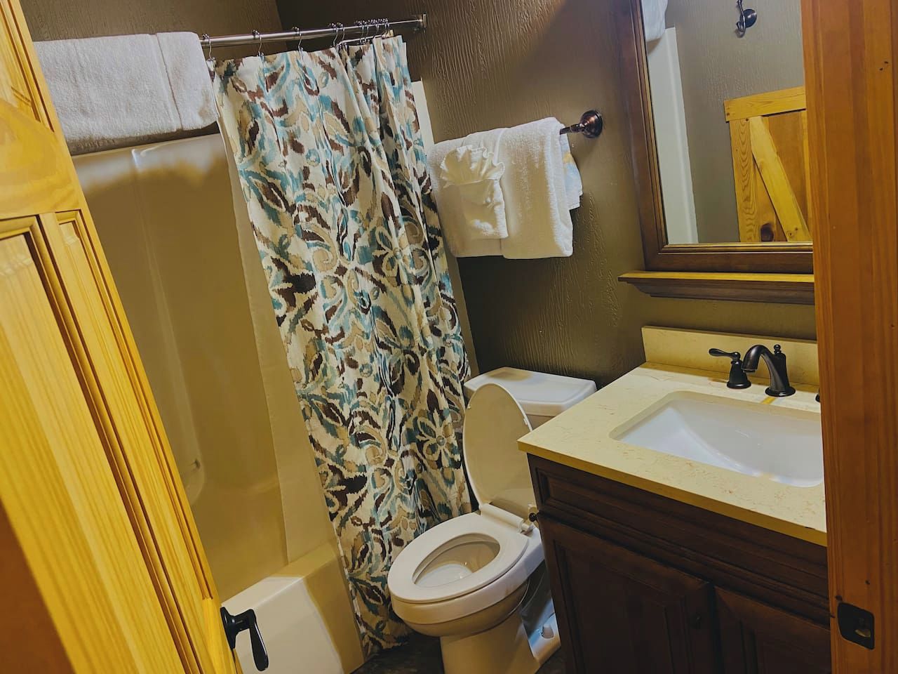 Une salle de bain équipée de toilettes, d’un lavabo et d’un rideau de douche.
