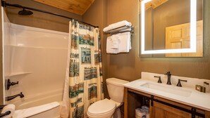 A bathroom with a bathtub, toilet, and sink.