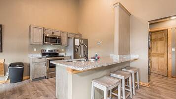 A kitchen with granite countertops, stainless steel appliances, and wooden cabinets.