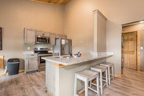 A kitchen with granite countertops, stainless steel appliances, and wooden cabinets.