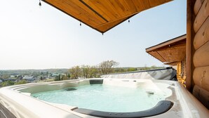 A hot tub with a wooden deck and a view of a town in the background. - Grandview Cabin Suite 30-Hot Tub, Dog Friendly (McHenry)