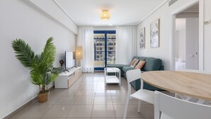 Una sala moderna con sofá, mesa de comedor y televisor.