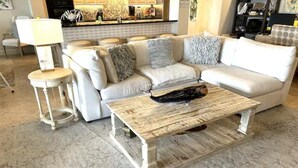 Un salon avec un canapé blanc, une table basse en bois et une lampe.