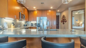 Una cocina moderna con una isla central, electrodomésticos de acero inoxidable y armarios de madera.