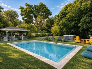 A rectangular swimming pool with a white deck edge, surrounded by a well-maintained lawn and trees. - Casa Palma | Pool + Hot Tub + Mini Golf (Miami)