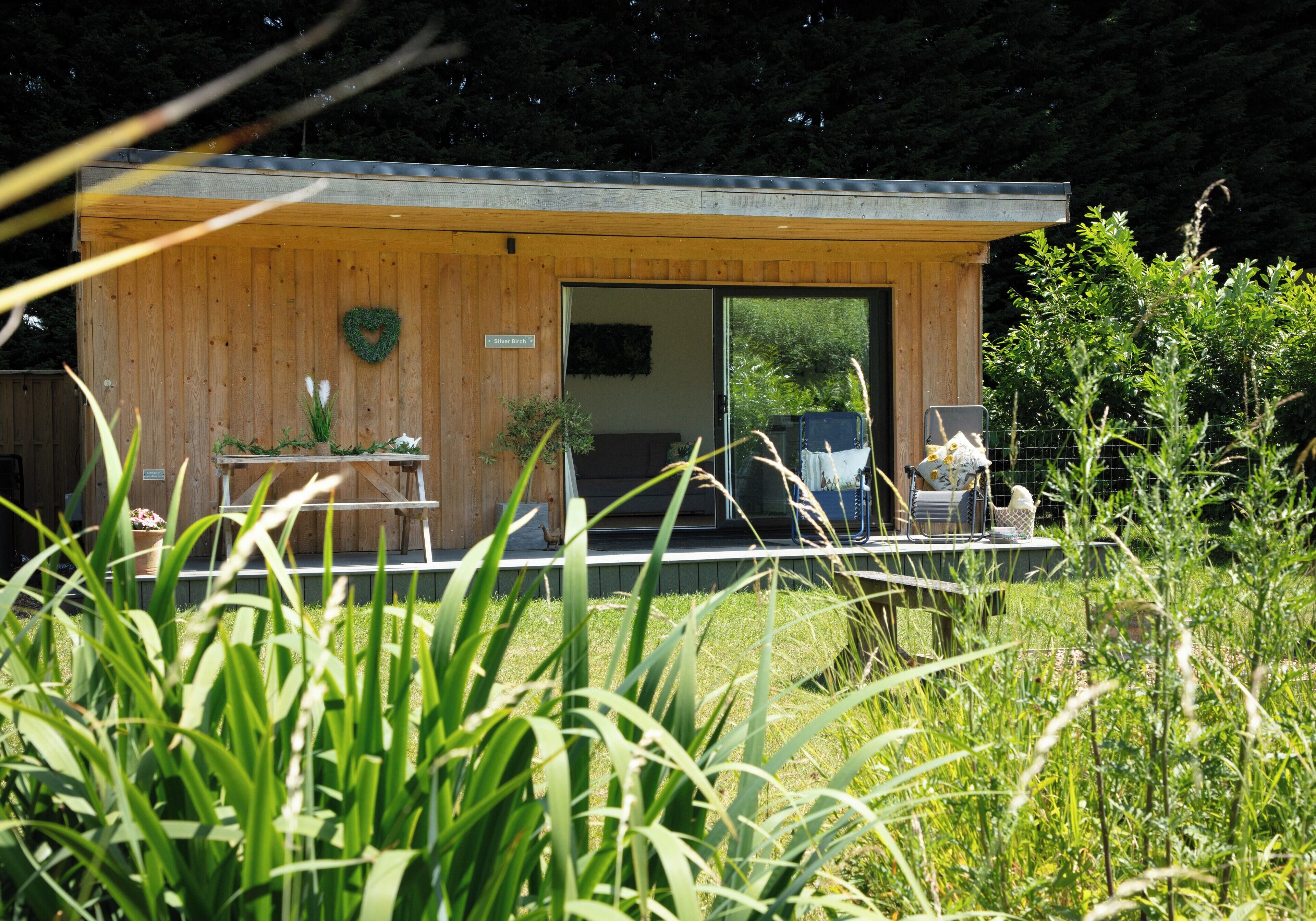A wooden cabin with a large door, a small porch area, and a sign indicating it is a guesthouse.