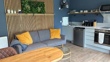 A modern kitchen with a built-in oven, microwave, and a wooden dining table.