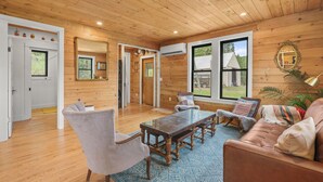 Un interior de madera con sofá, sillón y mesa.