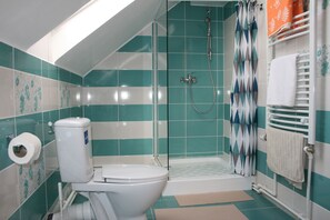 A bathroom with a toilet, shower, and bathtub.