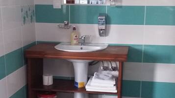 A bathroom with a sink, mirror, and towel rack.