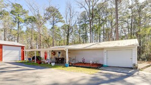 A single-story building with a covered porch, a garage, and a small garden area with potted plants. - Secluded Newport Getaway w/ Fire Pit & Grill! (Newport)