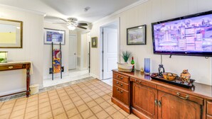 A hallway with a wooden cabinet, a television mounted on the wall, and a patterned rug. - Secluded Newport Getaway w/ Fire Pit & Grill! (Newport)