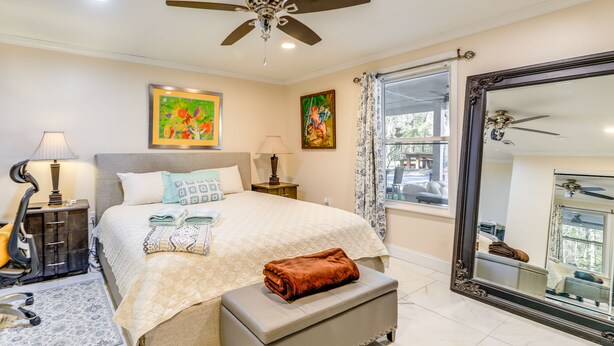 A well-lit bedroom with a bed, bedside lamps, a ceiling fan, and a large mirror. - Secluded Newport Getaway w/ Fire Pit & Grill! (Newport)