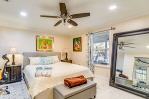 A well-lit bedroom with a bed, bedside lamps, a ceiling fan, and a large mirror. - Secluded Newport Getaway w/ Fire Pit & Grill! (Newport)