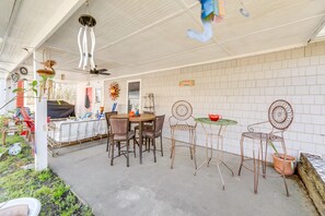 Un patio al aire libre con una mesa redonda, sillas y objetos decorativos.