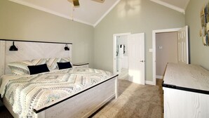 Une chambre à coucher avec un lit, un ventilateur de plafond et un bureau.