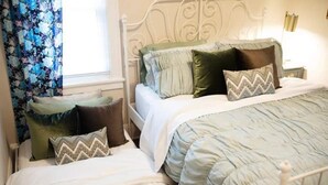 Une chambre d’hôtel avec deux lits, chacun ayant un style différent de literie et d’oreillers.