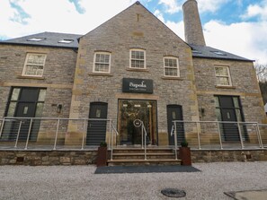 A stone building with a sign reading "The Cupola." - Rock Mill Apartment (Hope Valley)