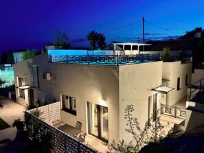 A modern two-story building with a balcony, a covered outdoor seating area, and a view of the surrounding landscape. - Luxury house Prestige (Split)