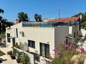A modern two-story building with a balcony, outdoor seating, and potted plants. - Luxury house Prestige (Split)