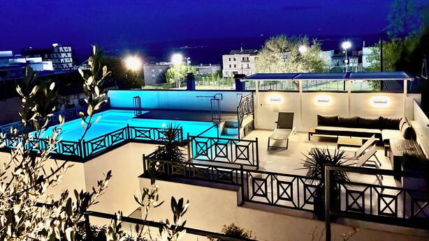A rooftop terrace with a pool, seating area, and a view of the cityscape at night. - Luxury house Prestige (Split)
