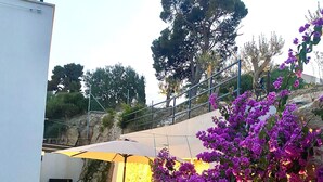 A garden area with purple flowers and a white building. - Luxury house Prestige (Split)