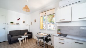 A compact living space with a kitchenette, a dining area, and a sofa.