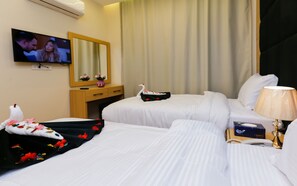 A hotel room with two beds, a TV, a mirror, a dresser, and a swan decoration. - Rizk Pyramids View Hotel (Giza)
