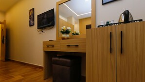 A modern bathroom with a wooden vanity, a mirror, a television, and a vase of flowers. - Rizk Pyramids View Hotel (Giza)