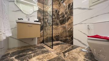 Habitación Deluxe con 2 camas individuales, vistas a la ciudad | Baño | Cabezal de ducha tipo lluvia y artículos de higiene personal gratuitos