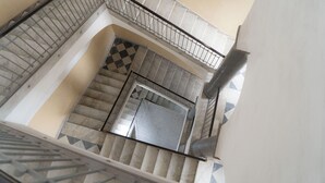 A multi-level staircase with a checkered floor pattern and metal railings.