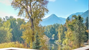Un balcon offrant une vue sur une montagne et les couleurs automnales des arbres.