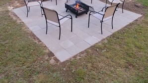An outdoor patio area with a fire pit and four chairs. - Cozy home in the heart of the Allagash.  Great for fishing, hiking, hunting, ect (Allagash)