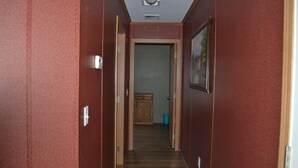 A narrow hallway with wooden flooring and red walls. - Cozy home in the heart of the Allagash.  Great for fishing, hiking, hunting, ect (Allagash)