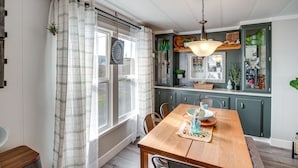 Un comedor con mesa de madera, sillas y una lámpara colgante.