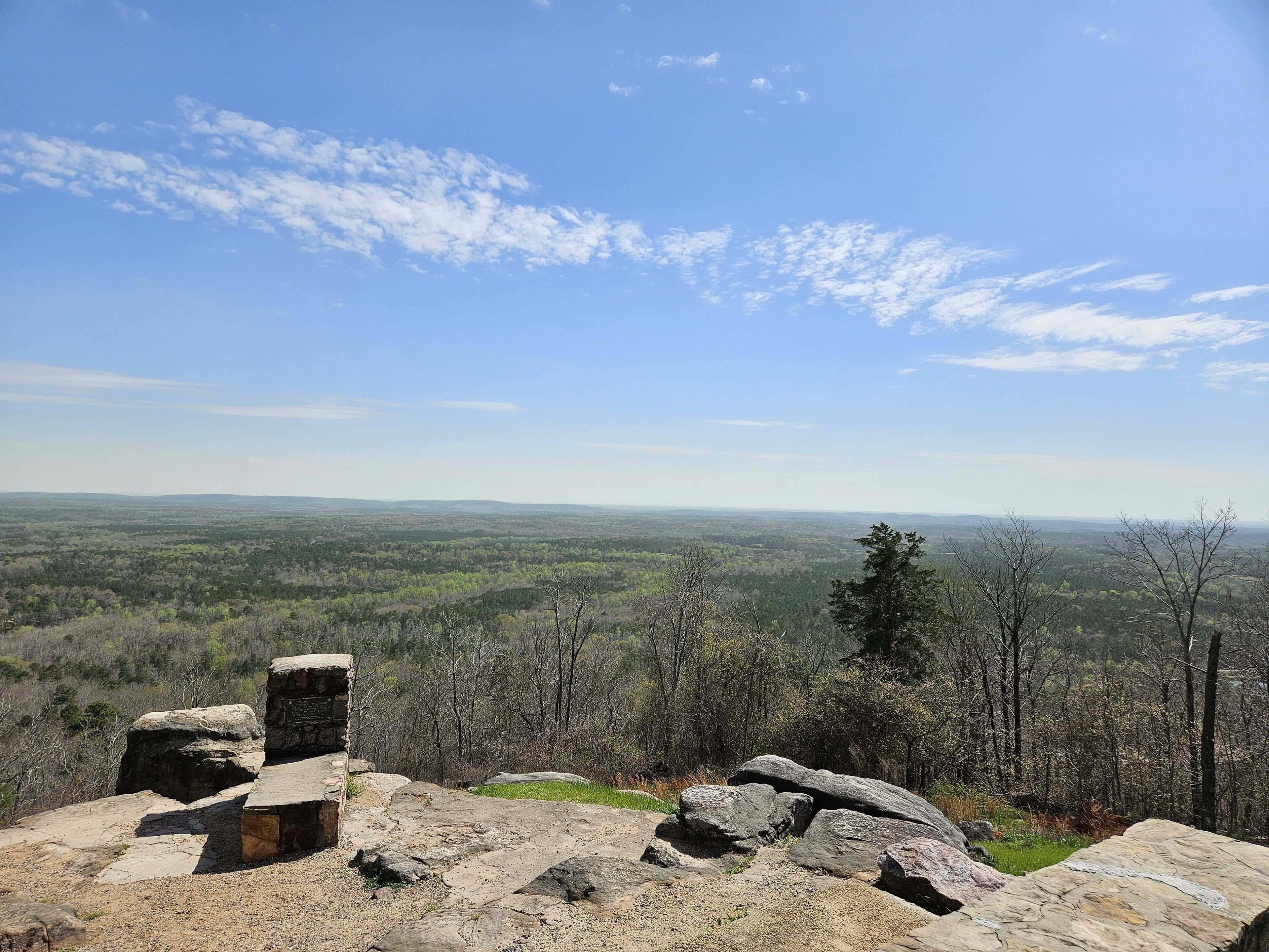 Une construction en pierre offrant une vue panoramique sur un paysage boisé.