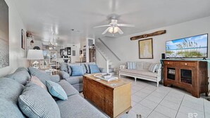 A spacious living room with a large sofa, a wooden coffee table, and a television.