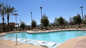 A swimming pool with lounge chairs and palm trees. - The Berkley (Las Vegas)