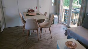 Un comedor con una mesa, sillas y un televisor montado en la pared.