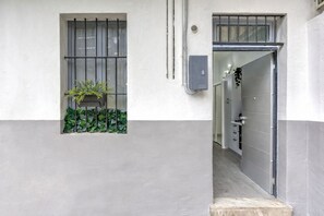 A narrow hallway with a window on the left and a door on the right. - Grazioso Moderno Monolocale San Donato - Vicino Metro Principi Dacaja (Torino)