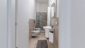 Een douche, een haardroger, een bidet, handdoeken
