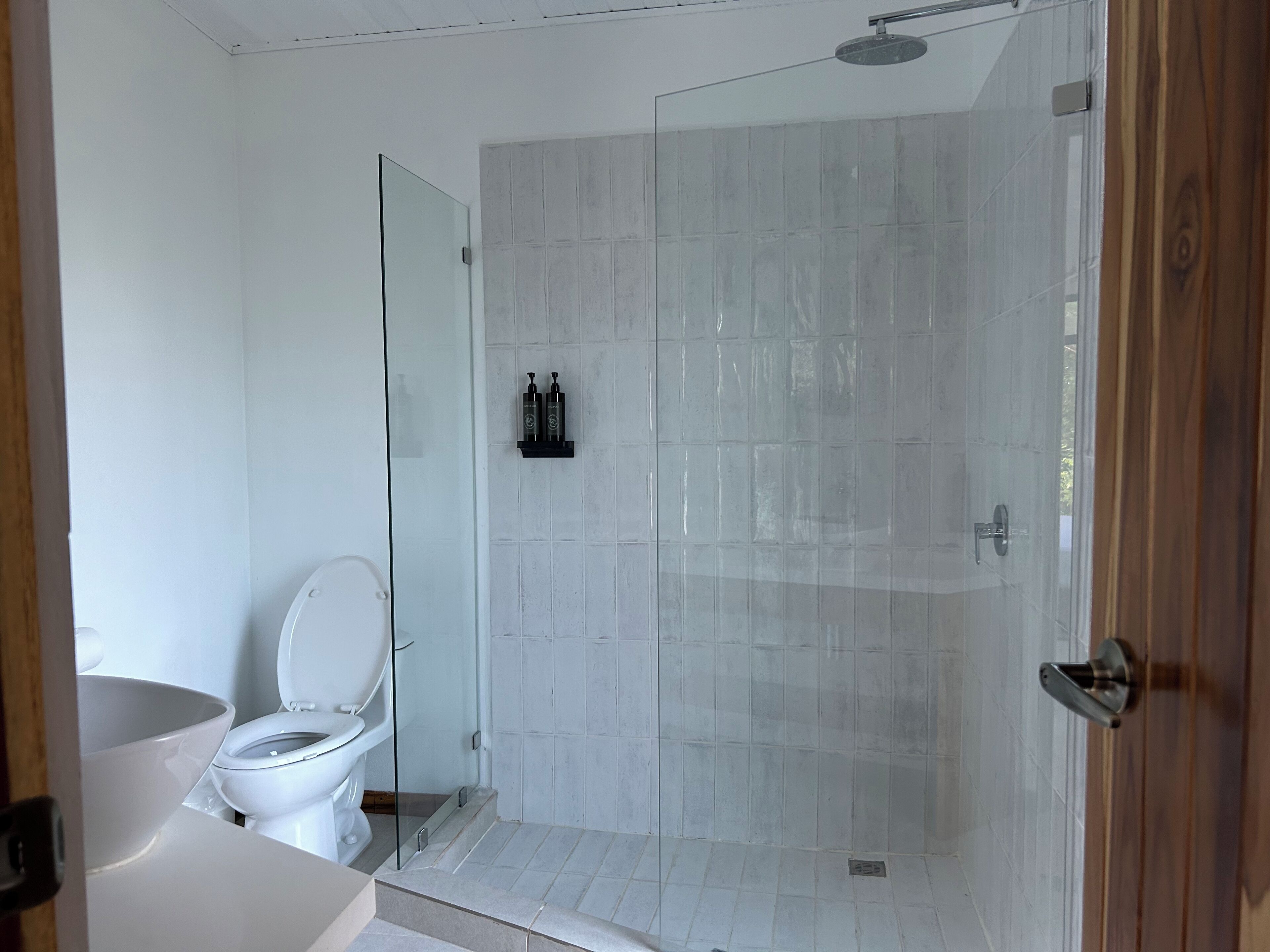 Ein Badezimmer mit Duschkabine, Toilette und Waschbecken.