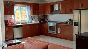A modern kitchen with wooden cabinets, a stainless steel refrigerator, and a built-in oven. - Amplia Casa Para Renta Vacacional en Mazatlán a Solo 6 Minutos de la Playa (Mazatlán)