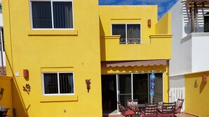 A yellow building with a patio area, a pool, and outdoor furniture. - Amplia Casa Para Renta Vacacional en Mazatlán a Solo 6 Minutos de la Playa (Mazatlán)